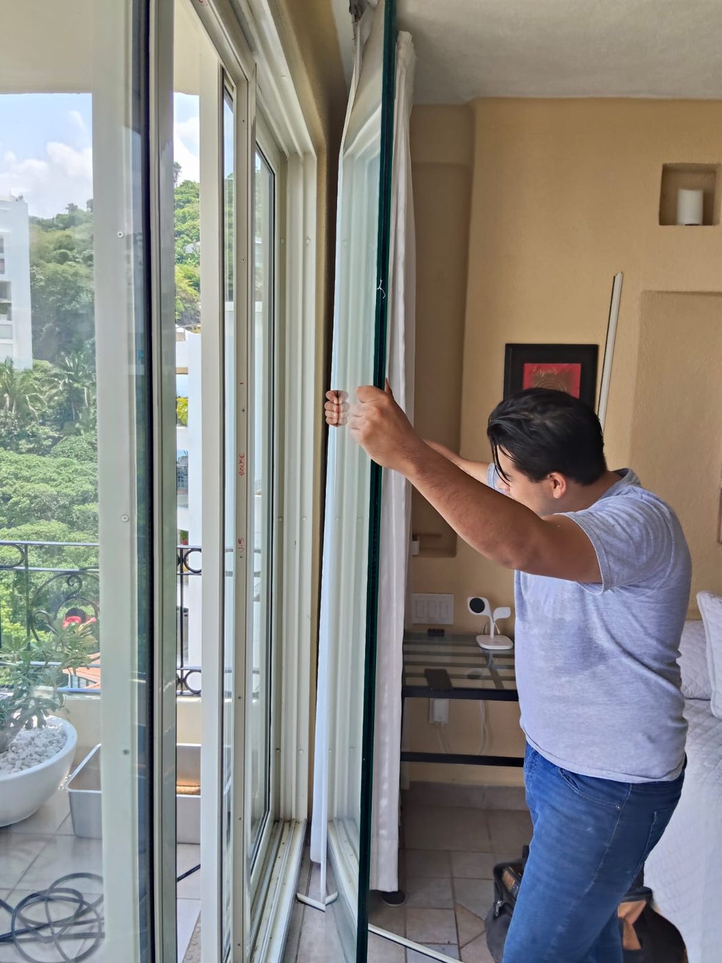 Vidrios y Aluminios VA technician fitting a glass pane in a Puerto Vallarta apartment