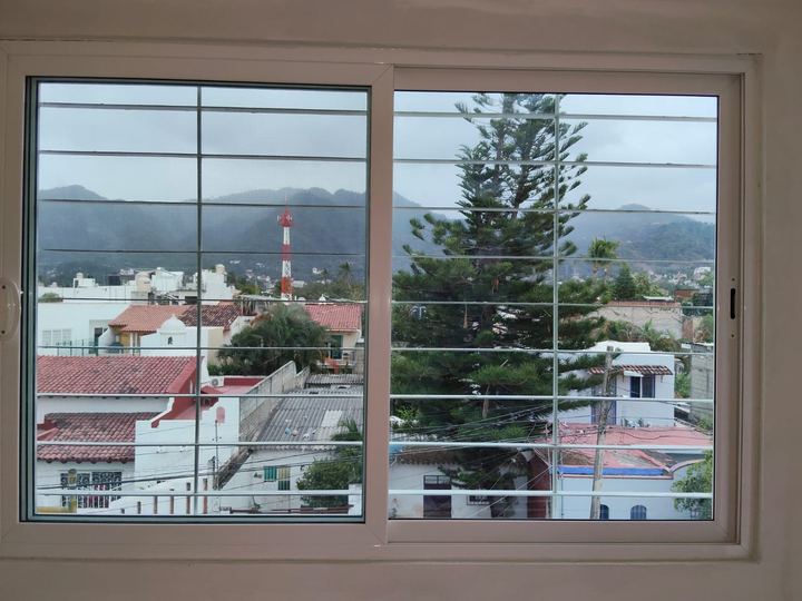 Ventana corrediza de aluminio con vista a la ciudad