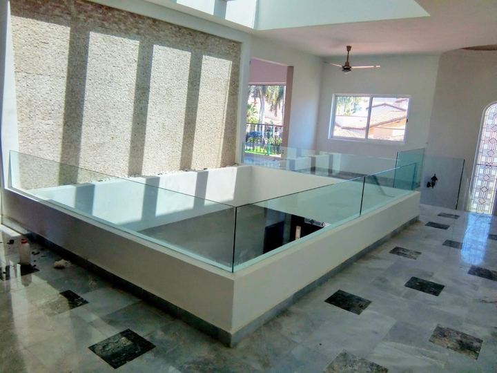 Tempered glass railing on a double-height interior balcony