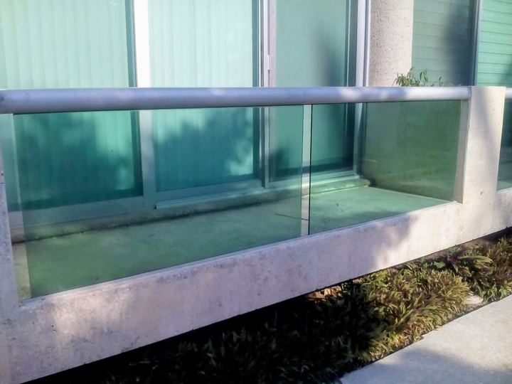 Tempered glass railing on a terrace with a steel handrail