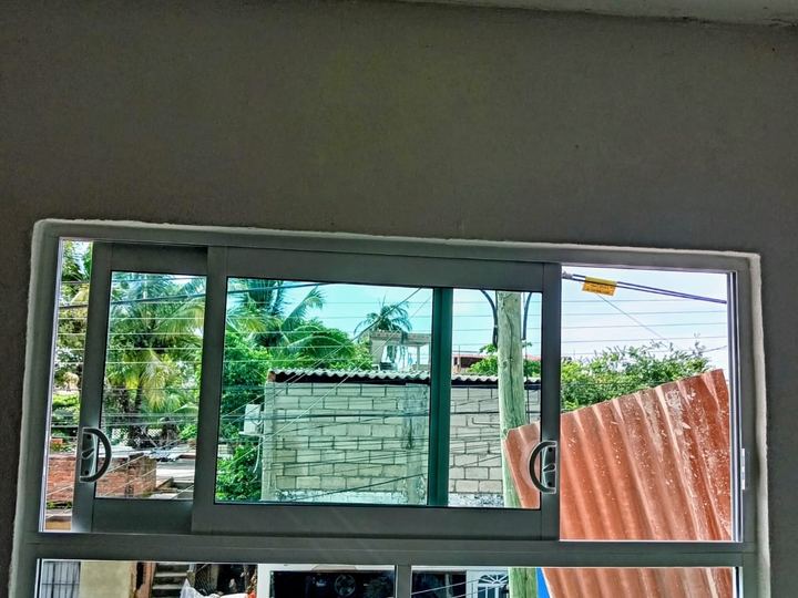Aluminum sliding window with a fixed lower panel in a kitchen