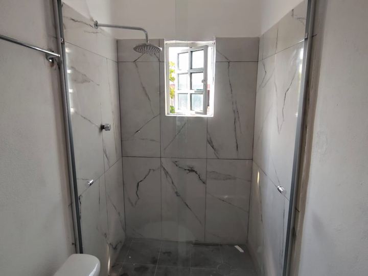 Cancel de baño con perfil cromado sobre mármol