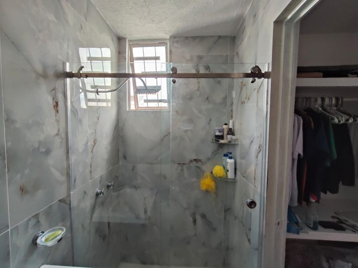 Cancel de baño corredizo sobre acabado de mármol