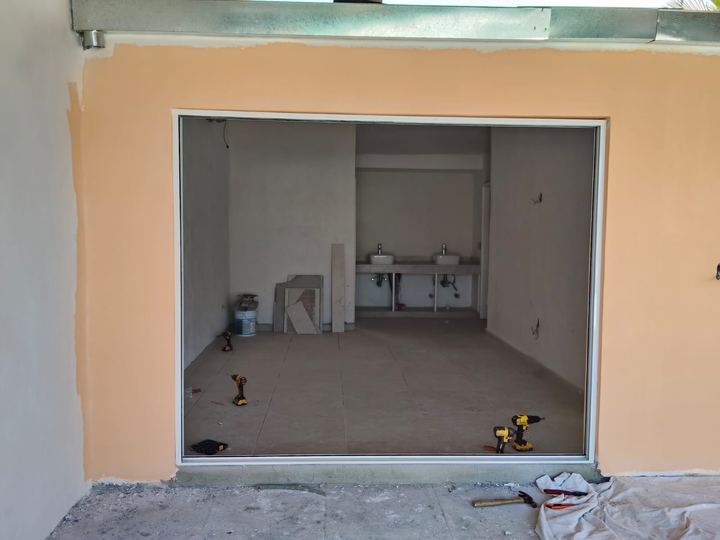 White aluminum sliding enclosure fitted in a large opening