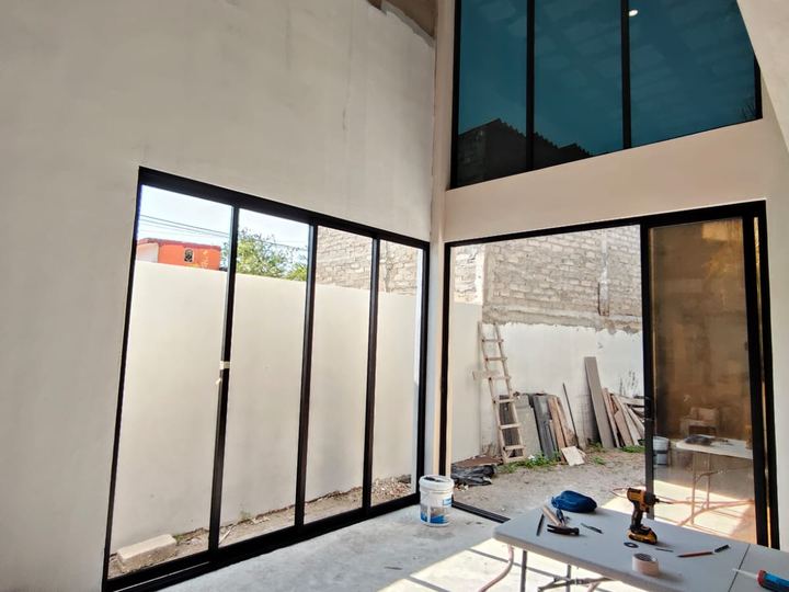 Double-height black aluminum glazing with tinted glass above