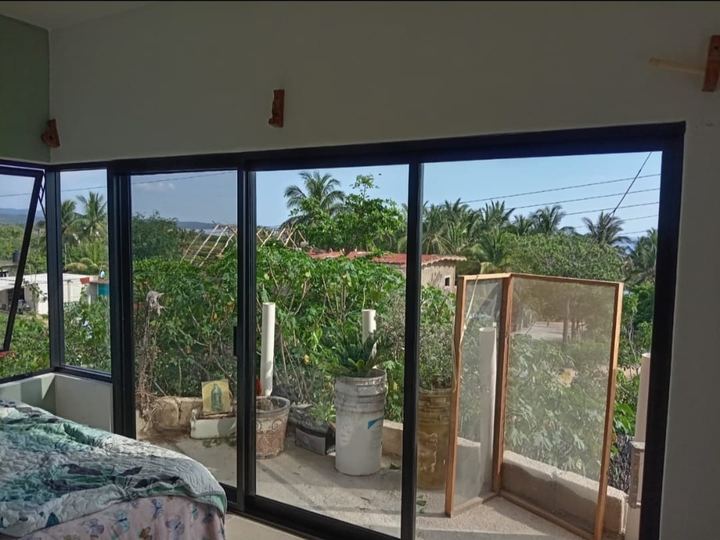 Bedroom with black aluminum sliding glazing overlooking the garden in Mayto