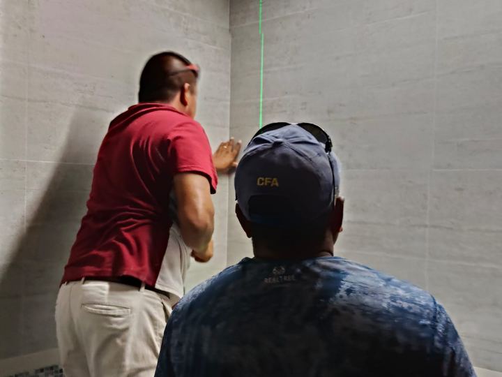 Custom mirror being installed with a laser level