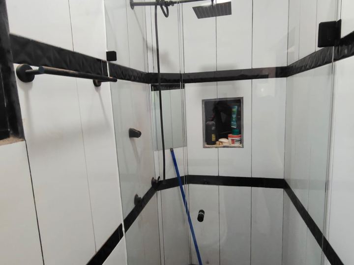 Tempered glass enclosure in a black and white bathroom