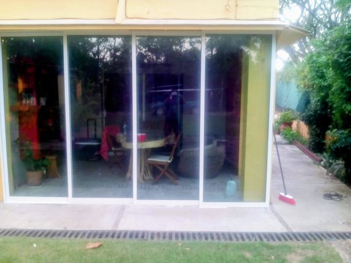 Four-panel white aluminum sliding enclosure onto the garden