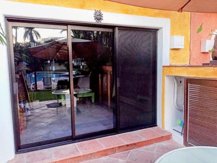 Wood-finish aluminum sliding enclosure with insect screen onto the pool