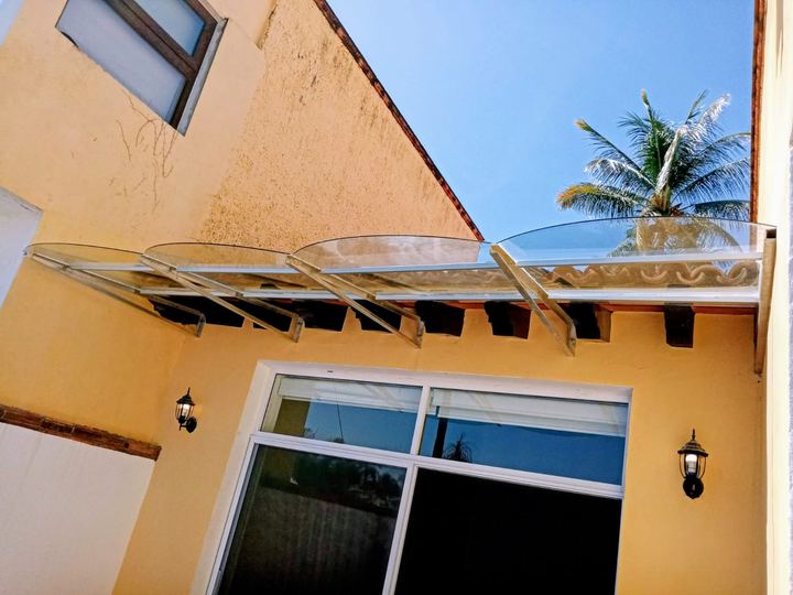 Curved acrylic canopy above a picture window