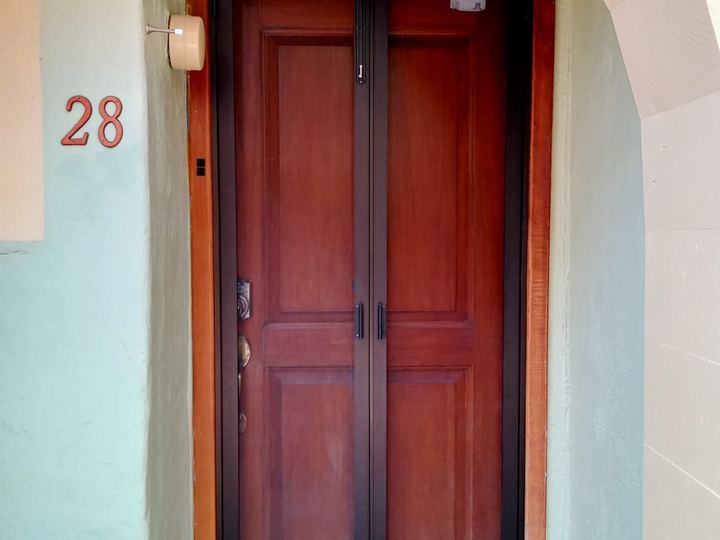Aluminum insect screen fitted over a wooden door