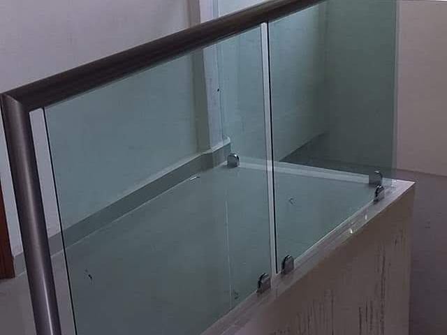 Tempered glass railing with a stainless steel handrail