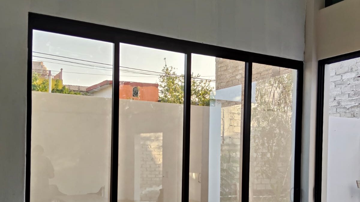 Puerta corrediza de aluminio negro con vidrio templado instalada en vivienda de Puerto Vallarta